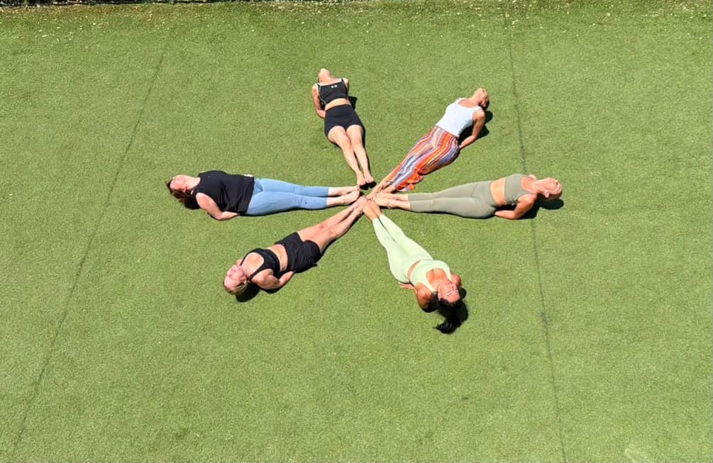 A class lying in a star on the grass after practice